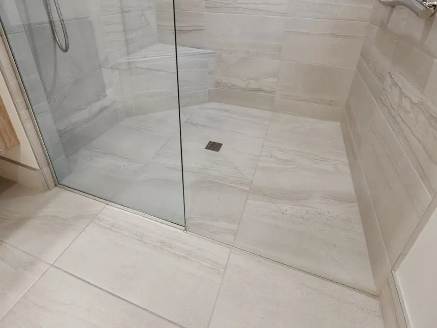 Tegelwerk in een gerenoveerde badkamer, afgewerkt na het leidingwerk